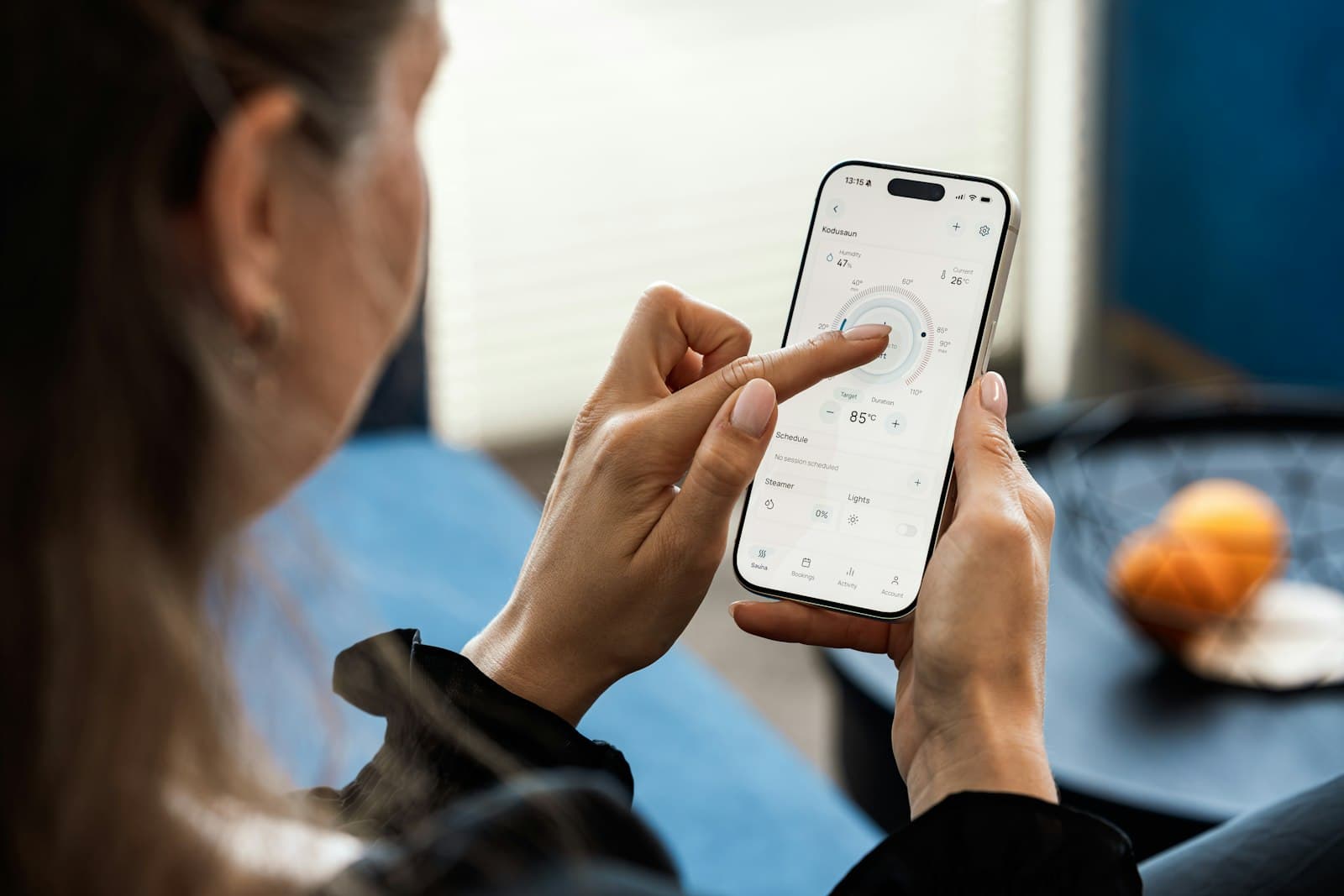 Akıllı ev uygulamasını telefonundan kullanan kişi