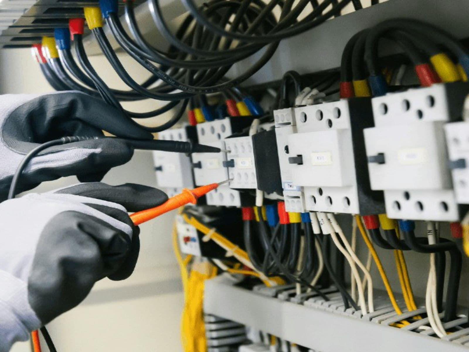 Elektrik panosunu multimetreyle test eden elektrikçi